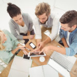Overhead view of business people with digital tablet while sitting at desk