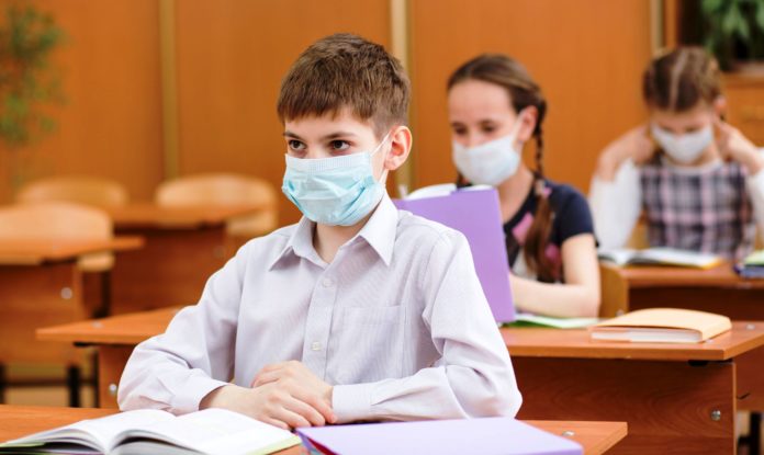 pupils with protection mask against flu virus at lesson