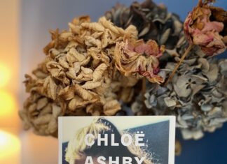 Livre "Repentirs" de Chloë Ashby posé sur une table à côté d'un bouquet de fleurs, photographie par Isabelle Arnould.