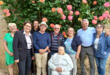 Germaine Mader entourée de sa famille sous le rosier qu'elle affectionne