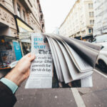 Man holding British newspaper The Daily Telegraph