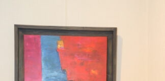 Femme artiste devant sa sculpture et son tableau