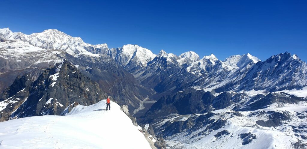 Sandrine Roy sur le Naya Kanga à 5 850 m avec en fond le Tibet lors de son séjour de 3 mois sans vélo au Nepal pour grimper au Langtang.