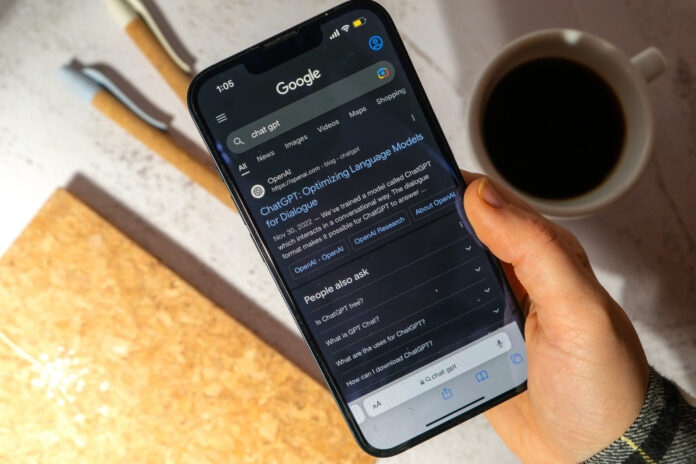 Gdansk, Poland - March 2023 Female hand holding cellphone Chat GPT app icon on screen of mobile phone iPhone Apple. Website of US American artificial intelligence company OpenAI LLC. Webpage prototype AI chatbot