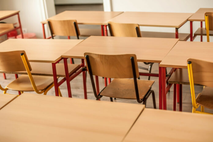Chairs and tables inside empty classroom in primary school. Close up