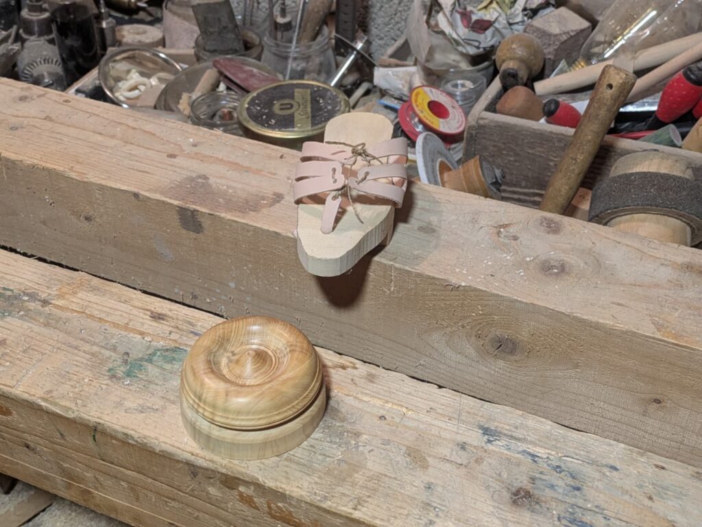 Prototype de semelle en bois et rondelle décorative liés aux fouilles chemin Trablettes Izernore.