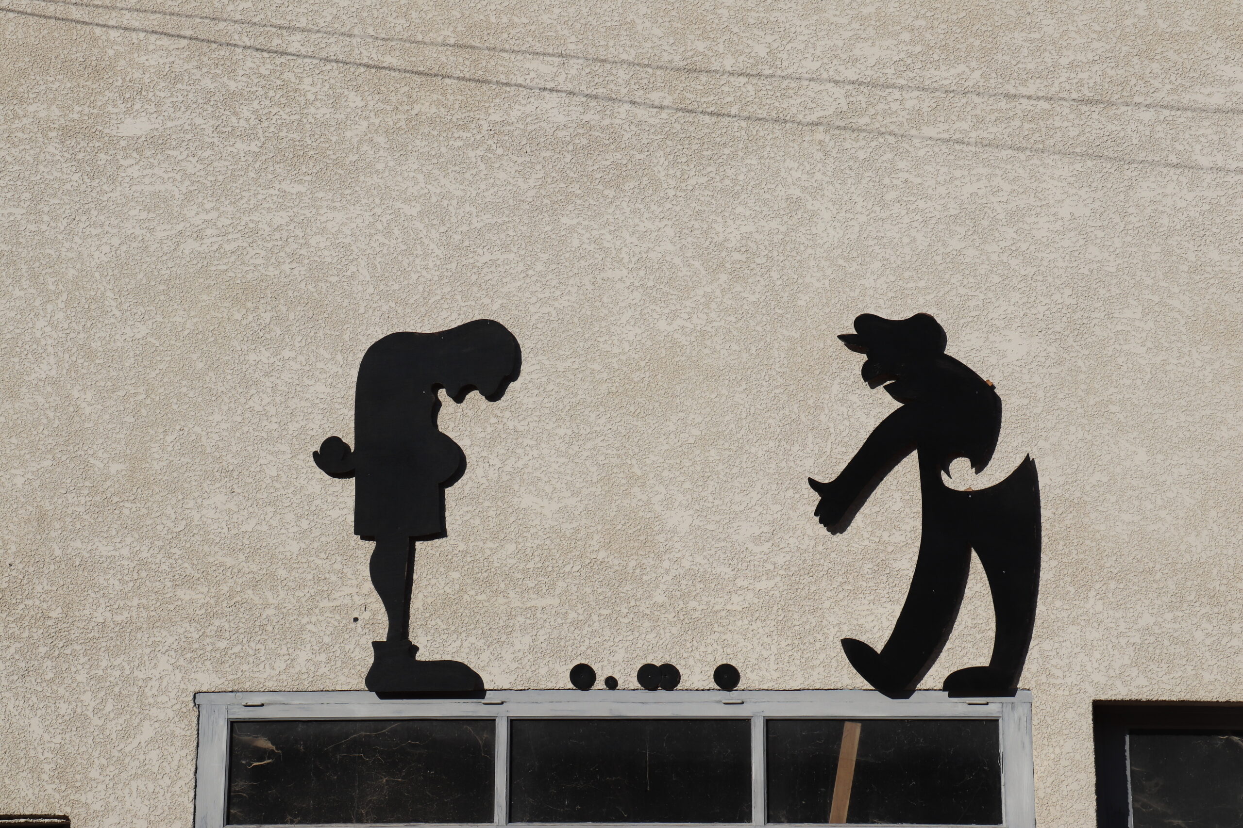 Des joueurs de pétanque représentés sur une façade.