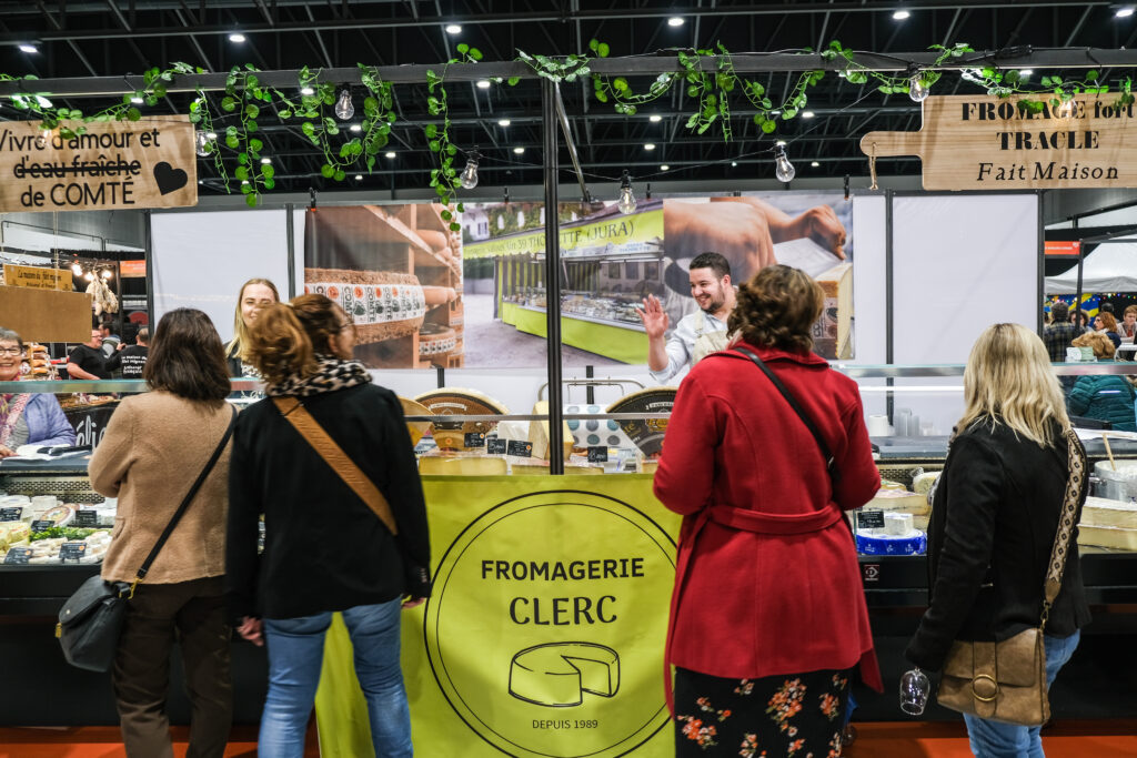 Exposants du salon Plein les Papilles proposant leurs mets et vins aux visiteurs.