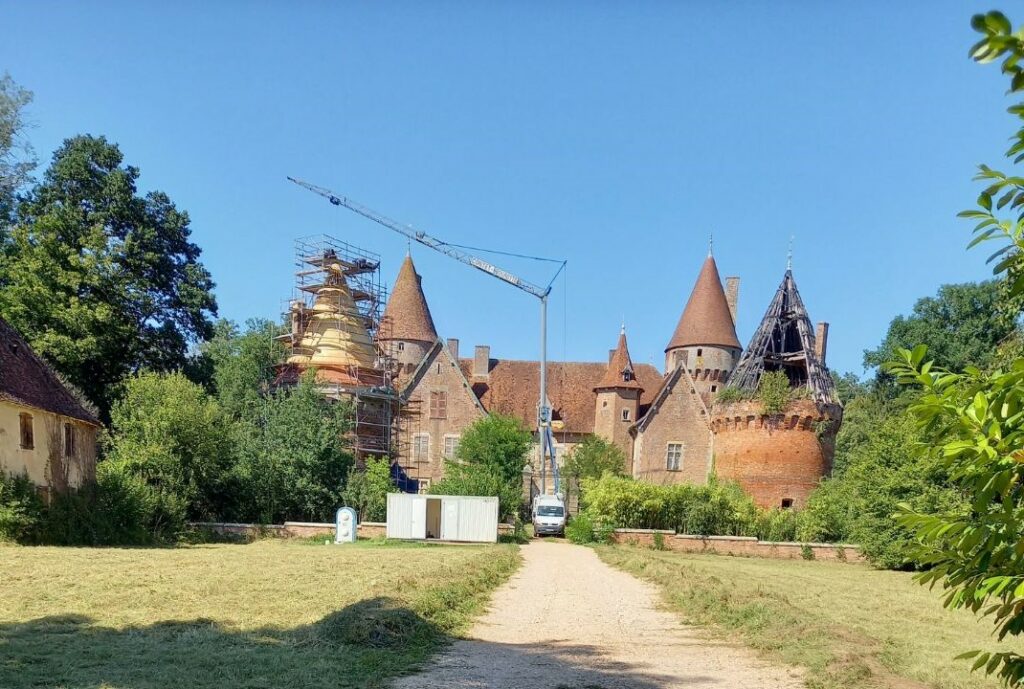 Travaux de réinstallation du tuilage avec des tuiles arrondies à la main par un artisan au chateau de Montcony