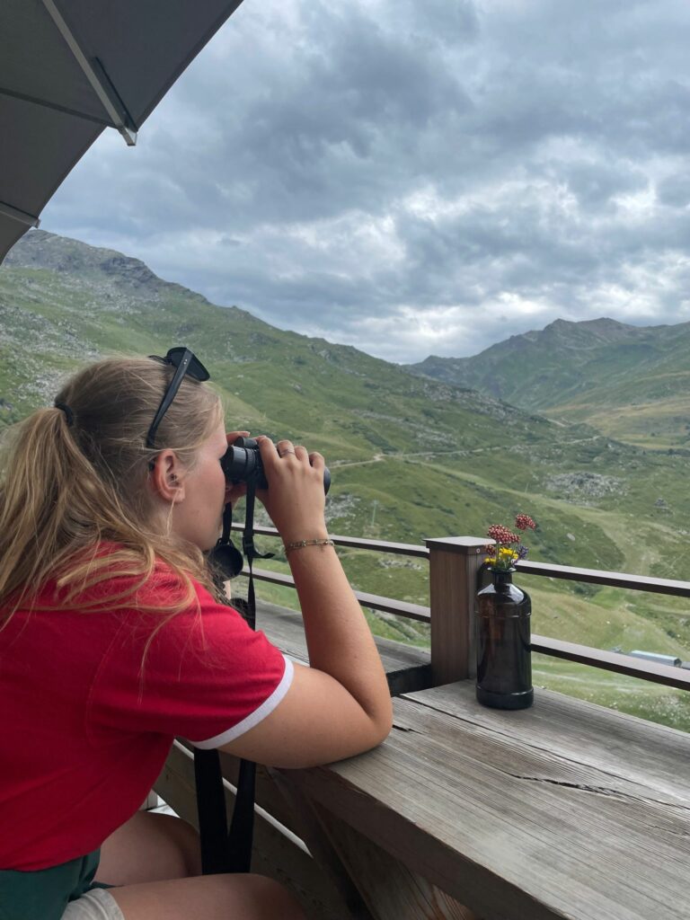 Stella observe au loin avec des jumelles