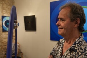 Tableau abstrait coloré présenté sur mur de galerie
