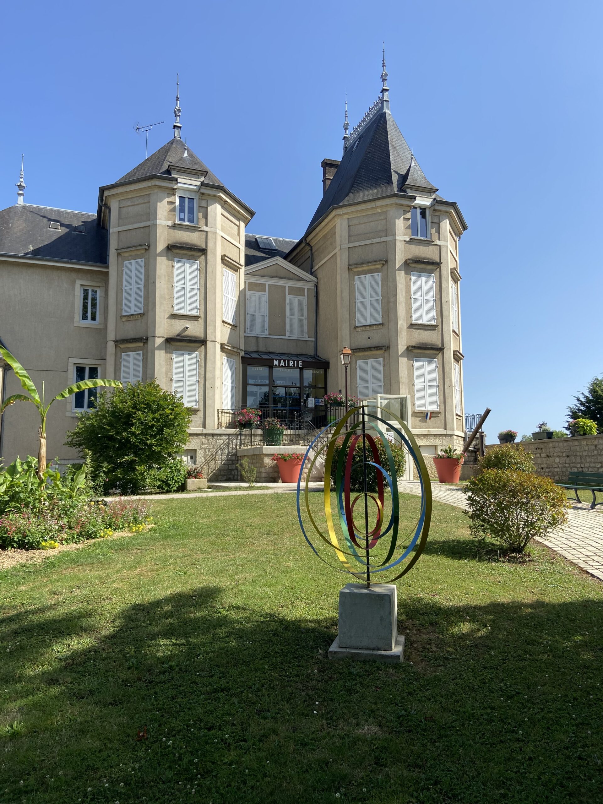 Massif de fleurs colorées devant bâtiment communal