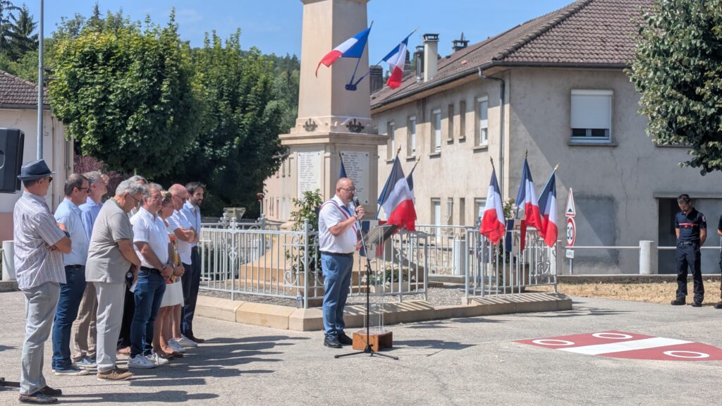 Maire et pompier hissant drapeaux au monument
